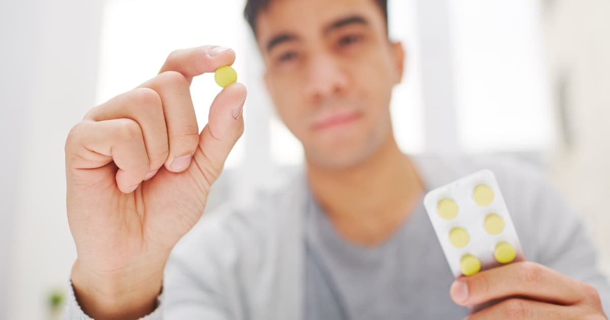 Man holding combination drug pill