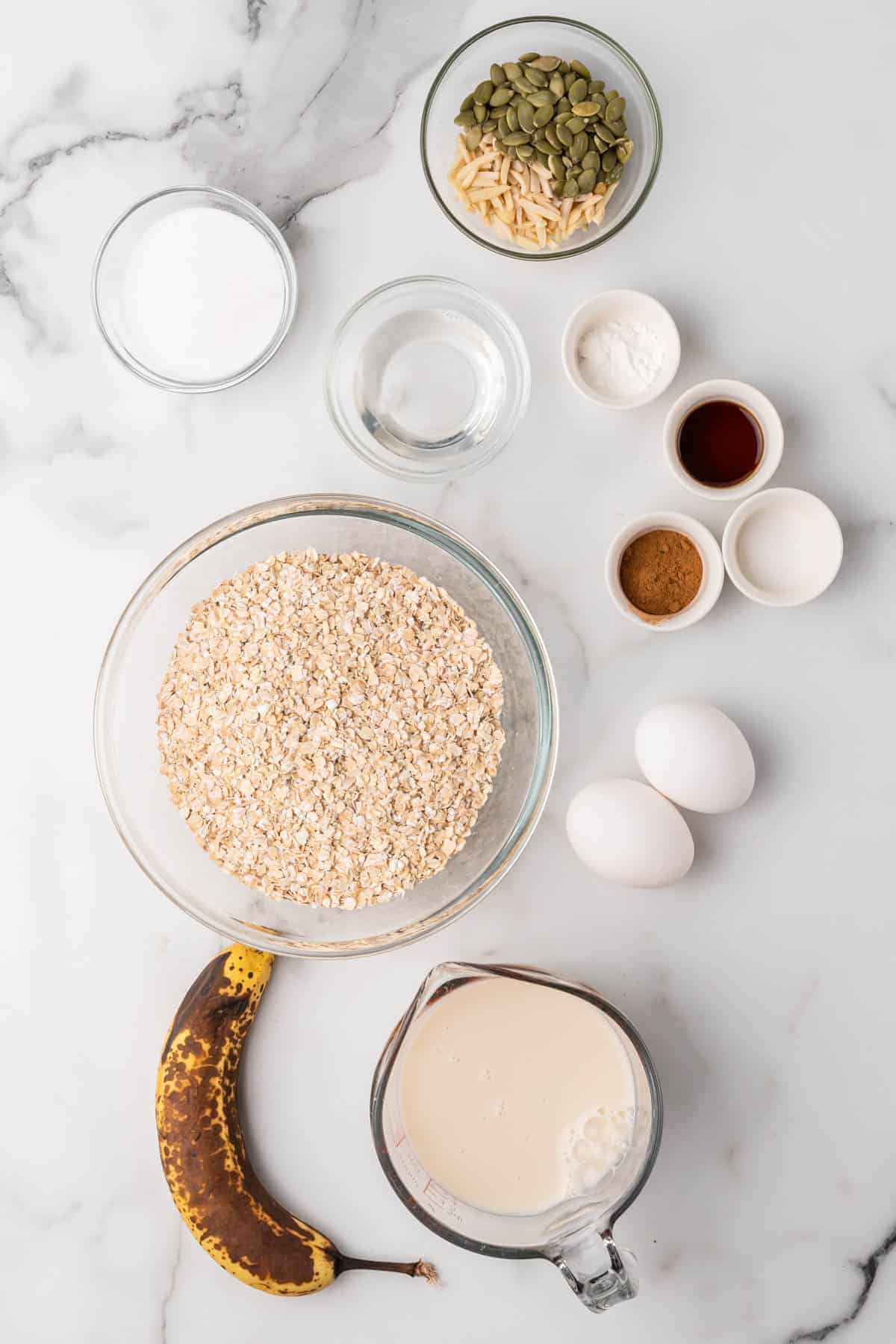 Ingredients in separate bowls and ramekins on a white backdrop, as seen from above