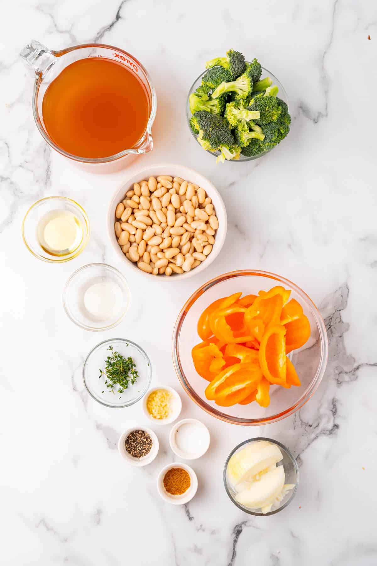 Ingredients for recipe separated into individual bowls and ramekins, as seen from above on a white marble countertop