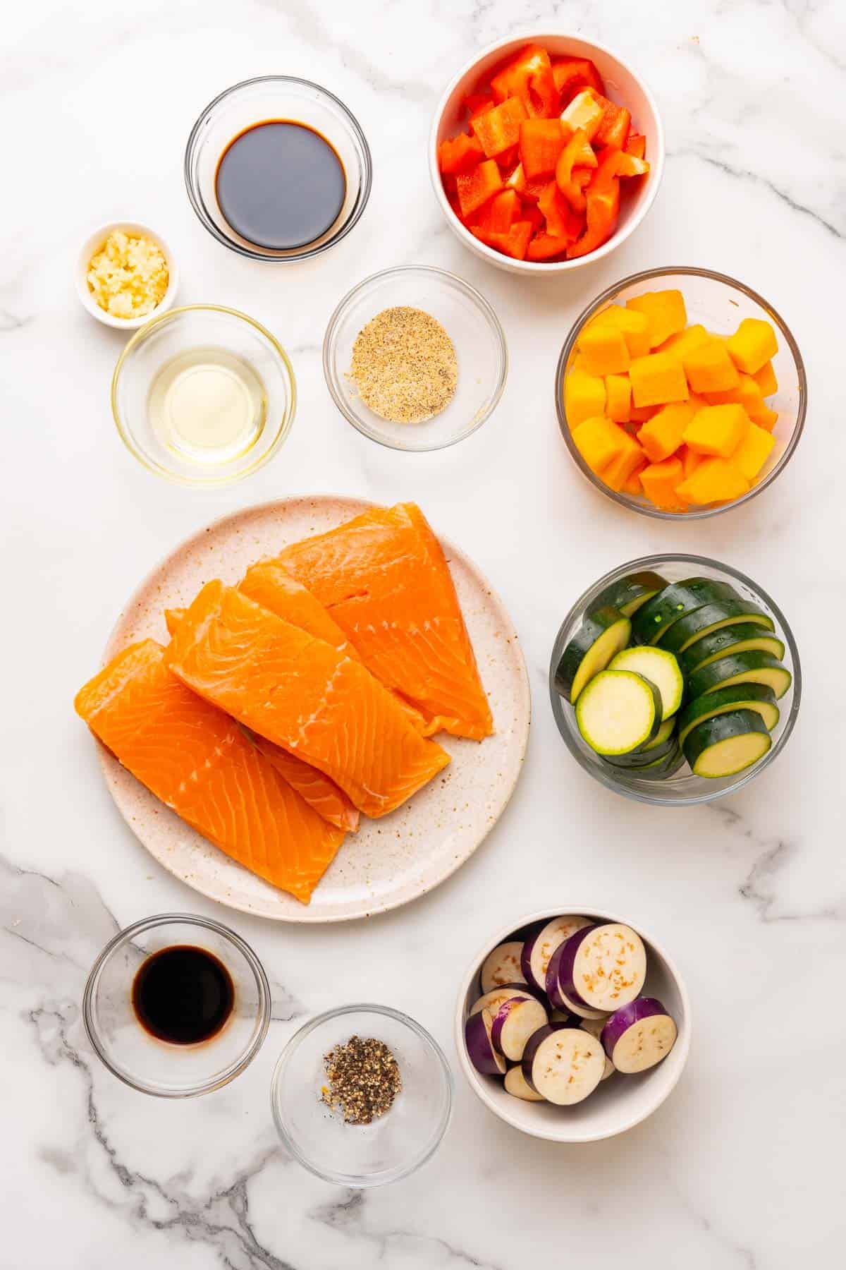 Ingredients for recipe separated into individual ramekins and bowls, as seen from above on a white marble countertop