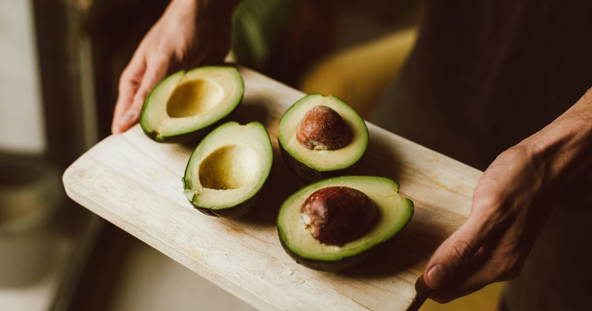 A cutting board with two sliced avocados on it