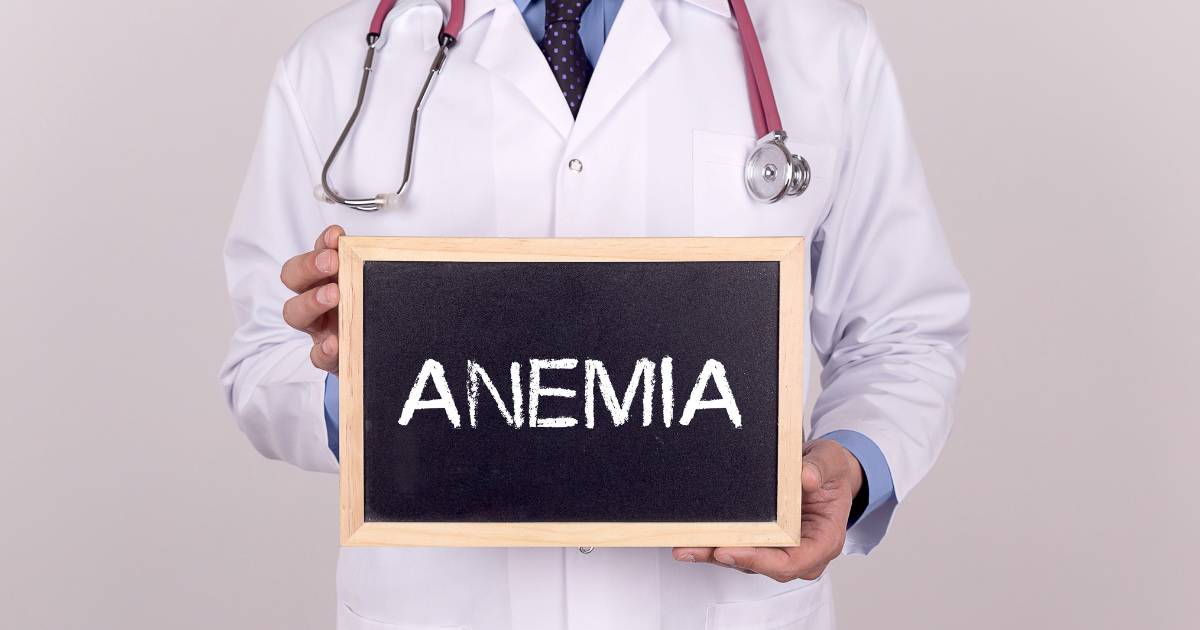 Doctor holds a chalkboard sign that says "anemia"