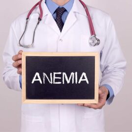 Doctor holds a chalkboard sign that says "anemia"