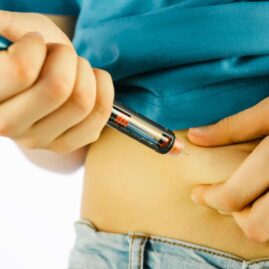 Image of person injecting a pen into their abdomen