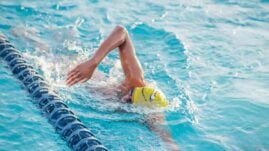 Person doing freestyle stroke in a swimming pool lane