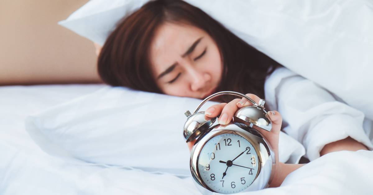 Image of woman snoozing her alarm.