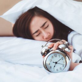 Image of woman snoozing her alarm.