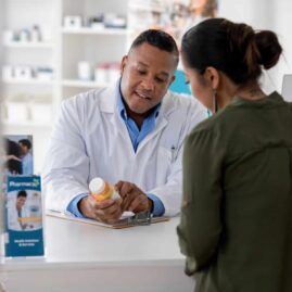 Image of a pharmacist explaining a medication to a customer.