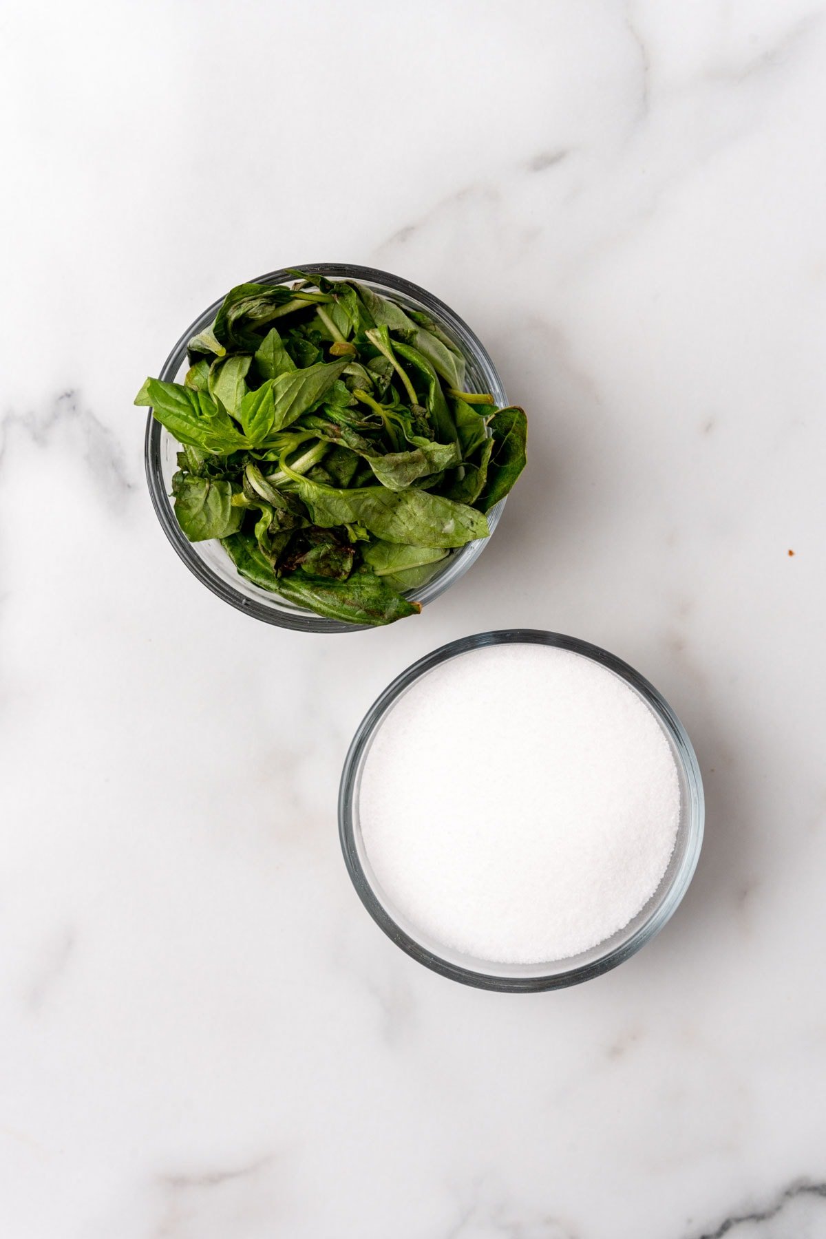 Glass bowls with salt and fresh basil on a table