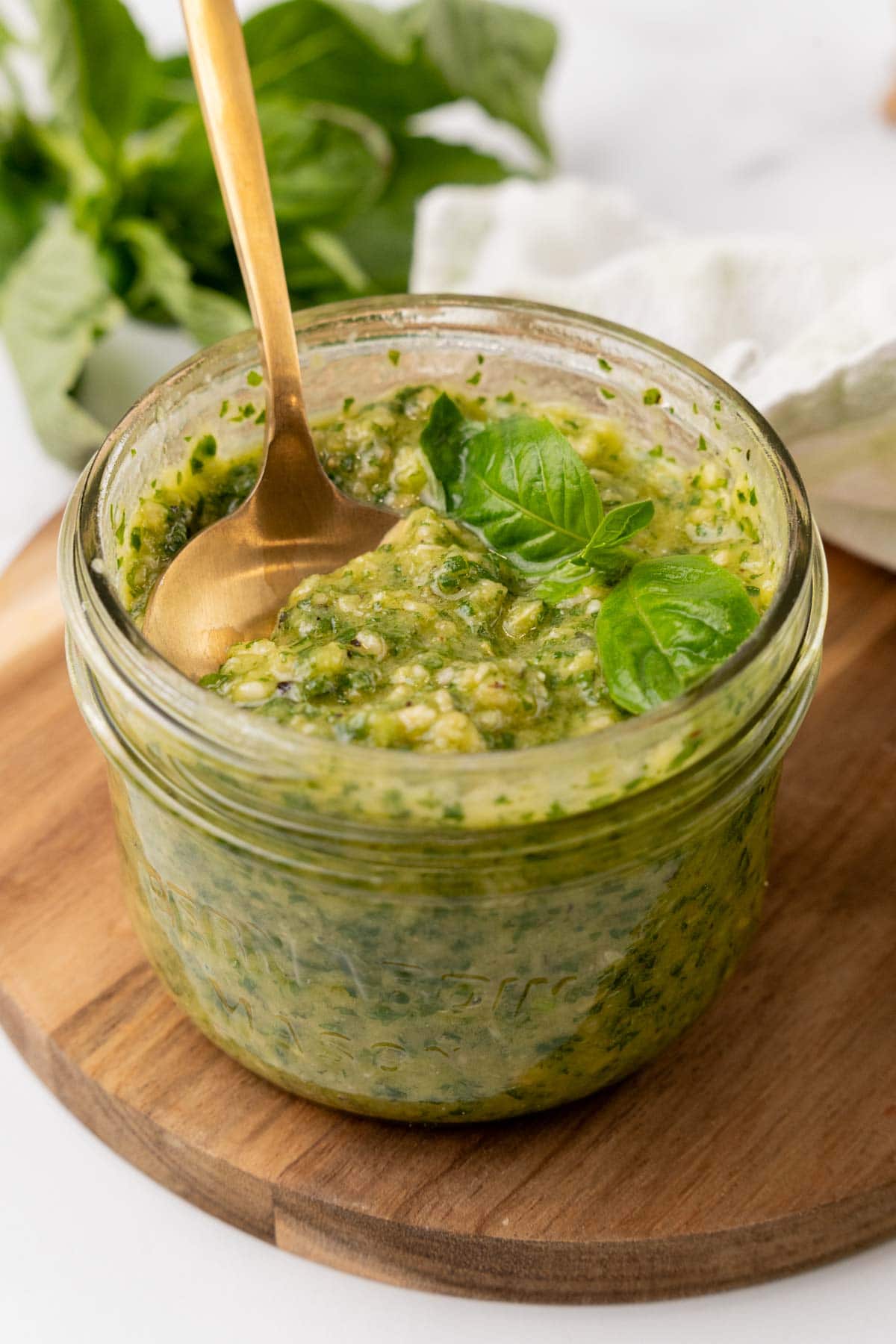 Glass of basil pesto with spoon