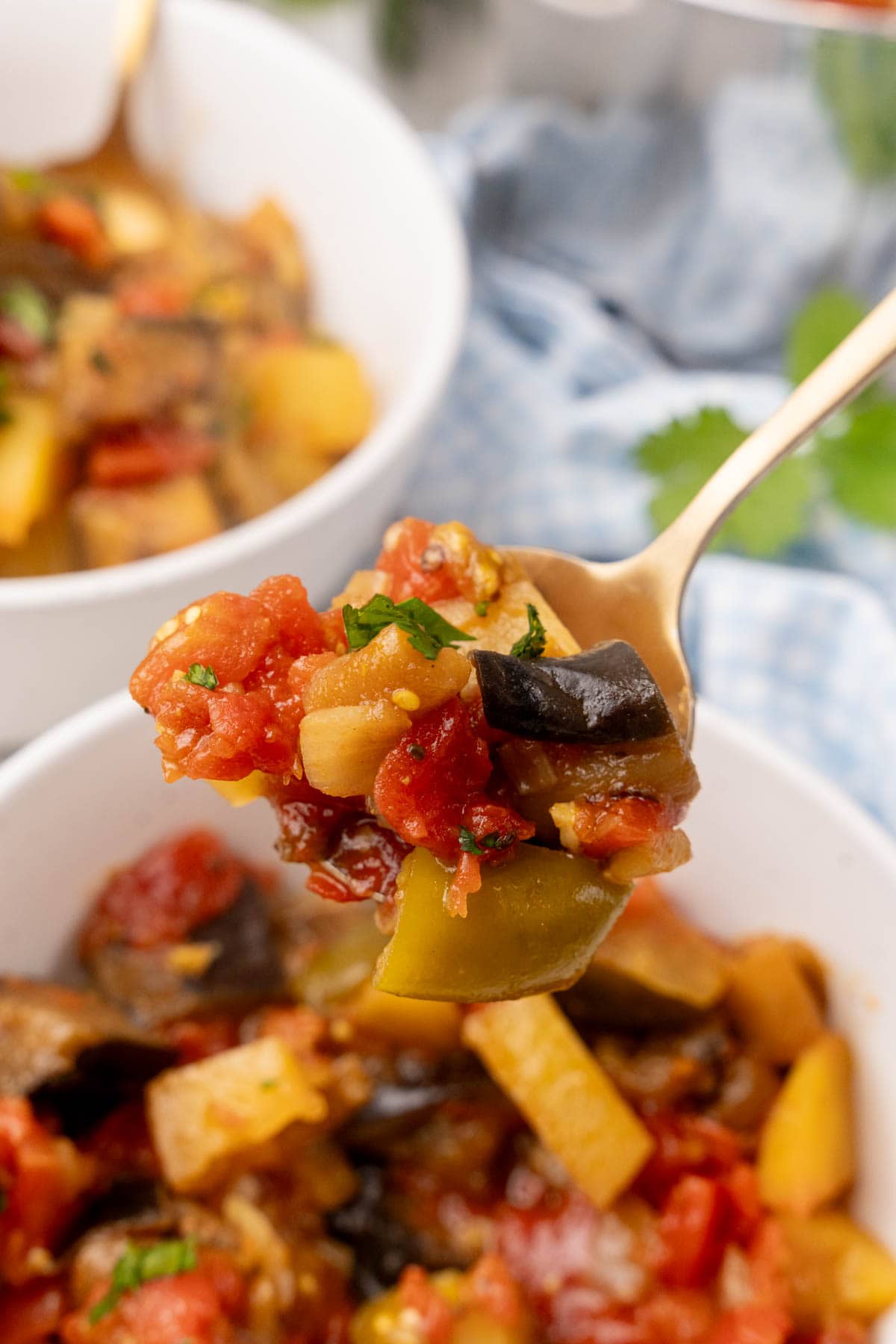 Spoonful of Moroccan eggplant stew held over bowl of stew