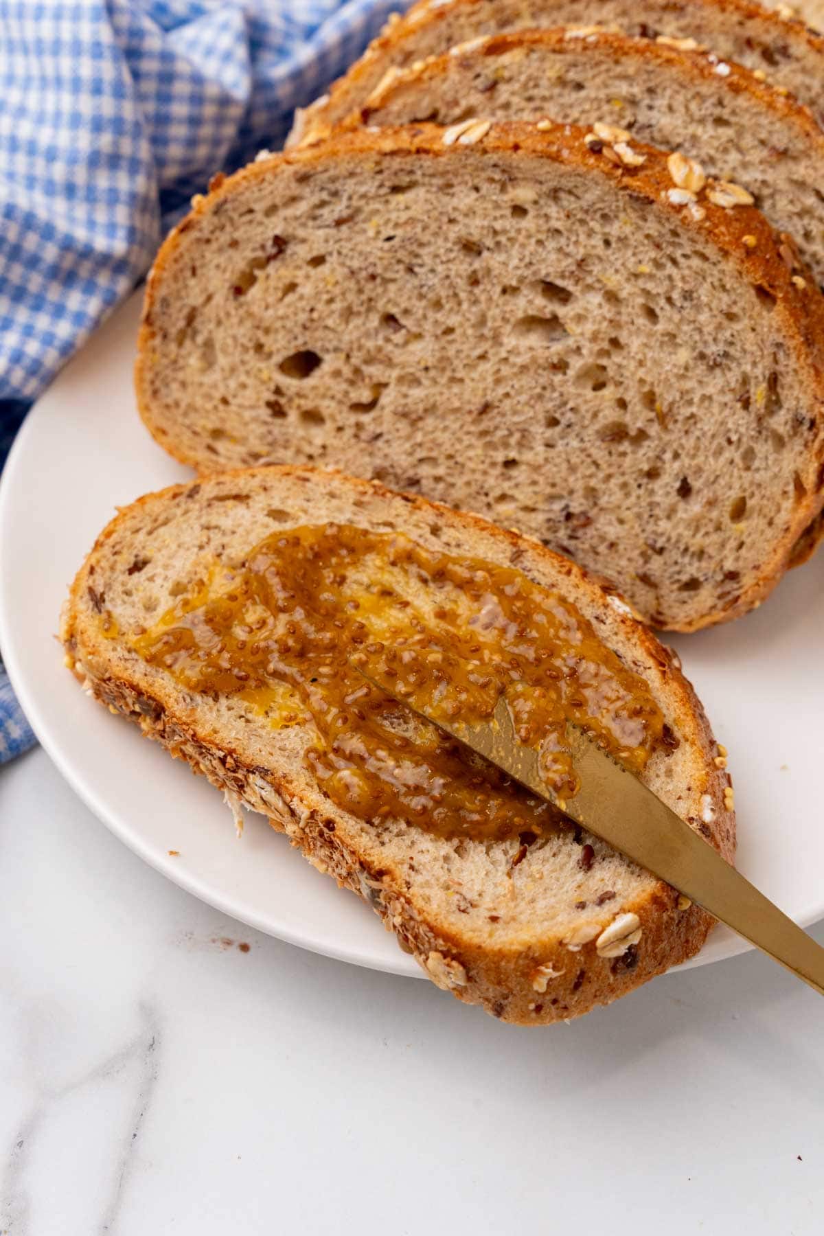 Jam being put on piece of bread with a knife