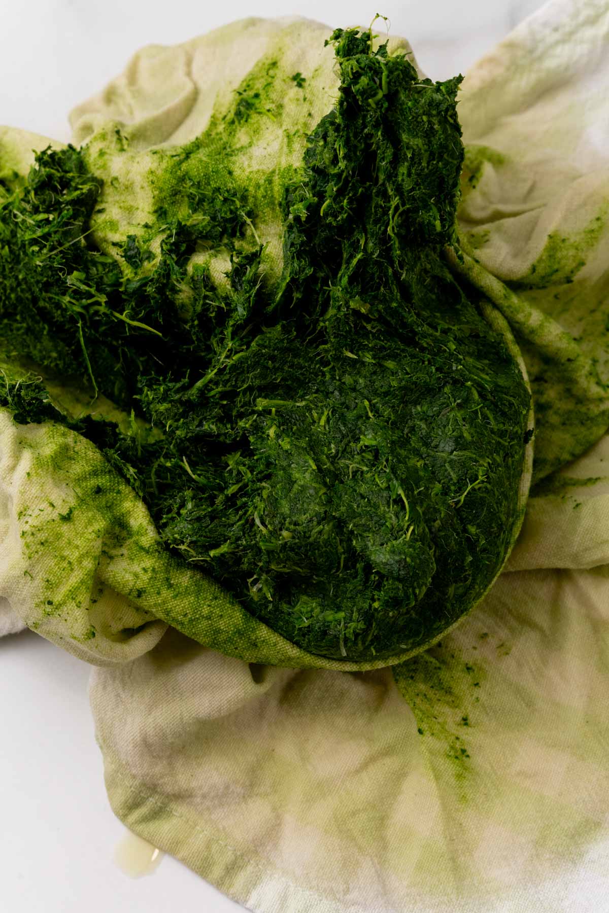 Spinach being squeezed in a cloth napkin