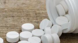 Metformin pills spilling out of a bottle onto a table