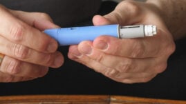 Hands holding an Ozempic pen