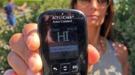 Woman holding blood glucose meter with HI reading