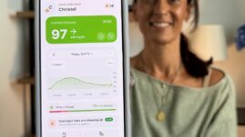 Christel holding phone with Sugar Sense app