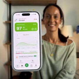 Christel holding phone with Sugar Sense app