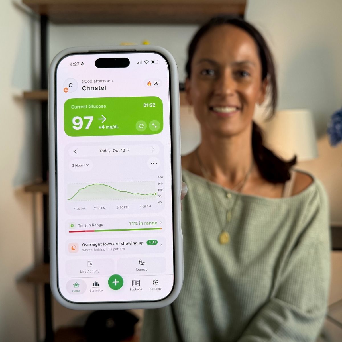 Christel holding phone with Sugar Sense app